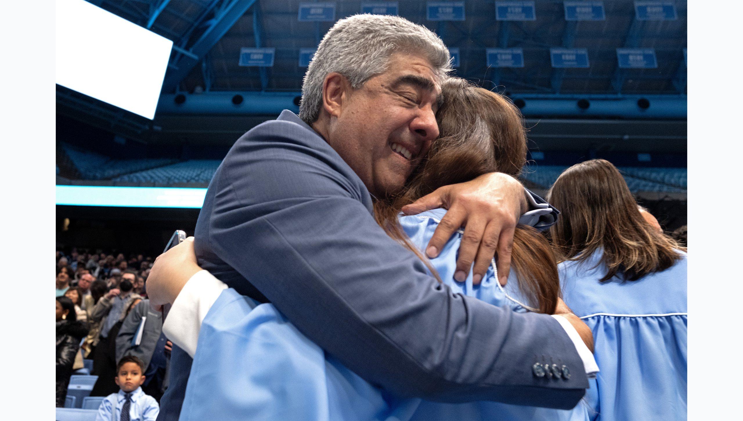 Graduate embracing her a family member with a hug at U.N.C. Chapel Hill's Winter Commencement.