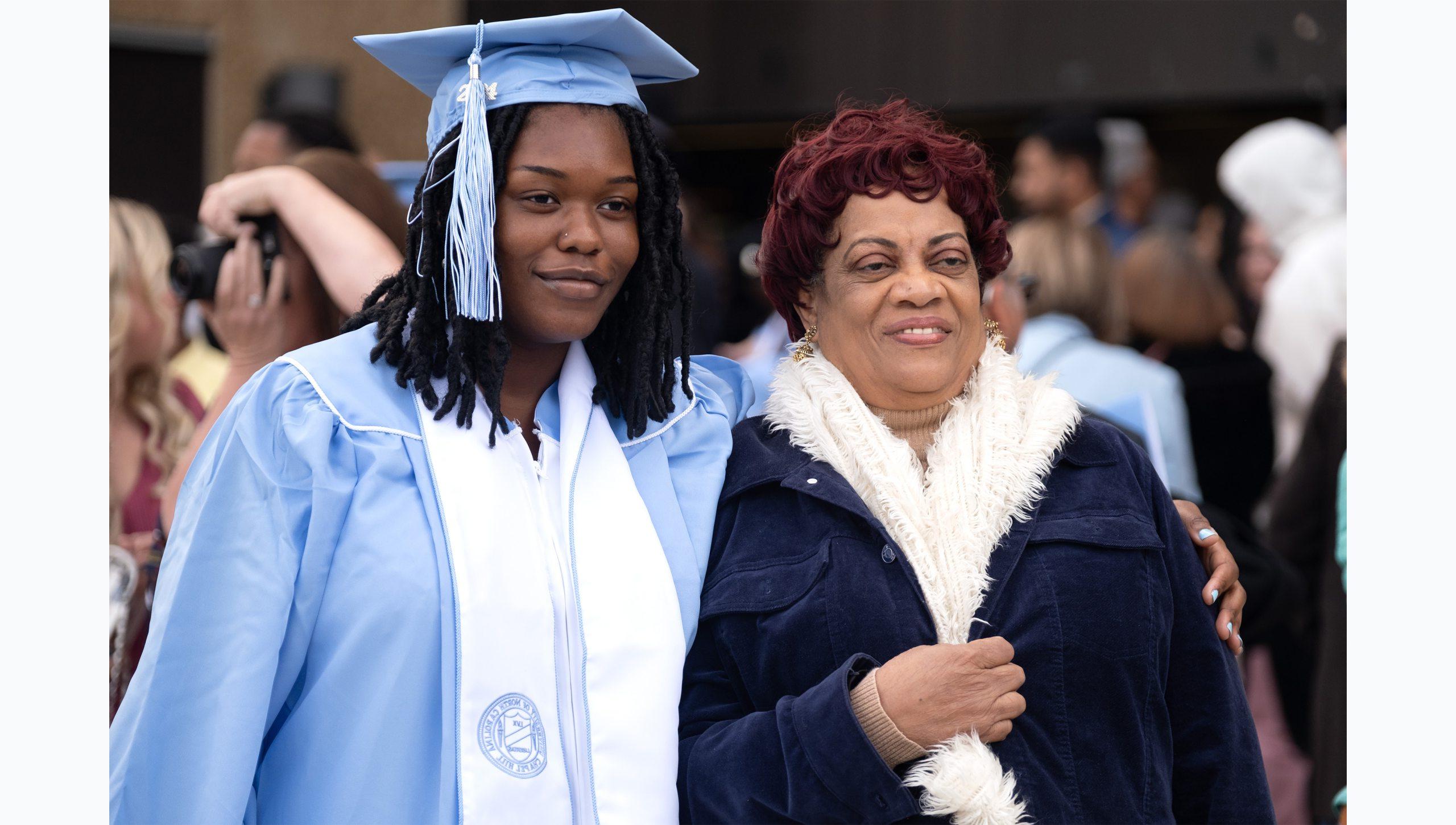 A female graduate posing for a photo with a woman following U.N.C. Chapel Hill's Winter Commencement.